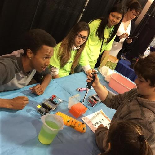 students doing science experiment at their booth students doing science experiment at their booth